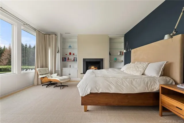 a bedroom with a bed and large windows