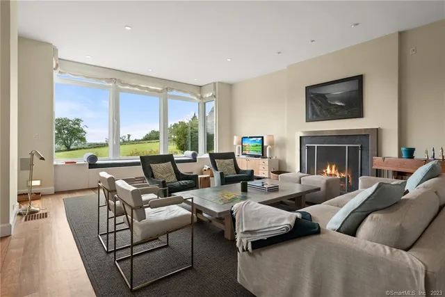 a living room with furniture large window and a fireplace