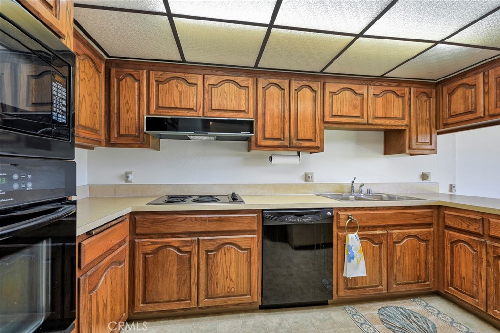 5555 Canyon Crest Drive, Unit 1F Riverside, CA 92507 - Photo 14 of 27 a kitchen with stainless steel appliances granite countertop a sink a stove and cabinets