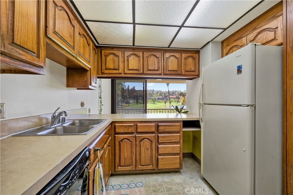 5555 Canyon Crest Drive, Unit 1F Riverside, CA 92507 - Photo 15 of 27 a kitchen with a refrigerator and a sink