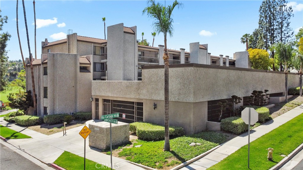 5555 Canyon Crest Drive, Unit 1F Riverside, CA 92507 - Photo 2 of 27 a front view of a house with garden and plants