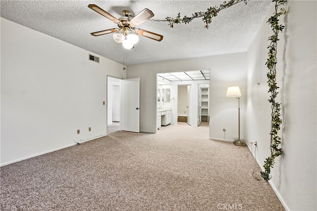 5555 Canyon Crest Drive, Unit 1F Riverside, CA 92507 - Photo 8 of 27 wooden floor in an empty room with a chandelier fan