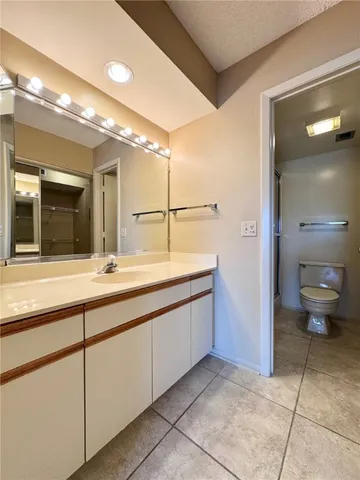 a bathroom with a double vanity sink toilet and a mirror