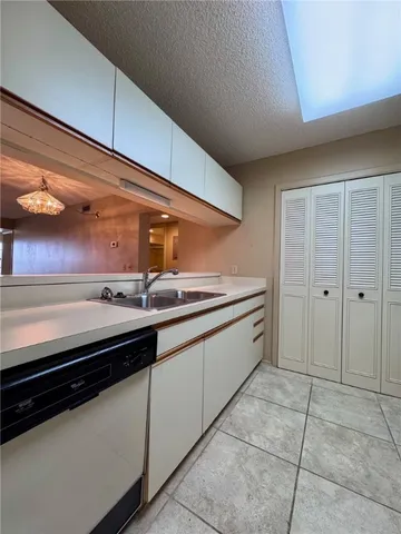 a large kitchen with stainless steel appliances a sink and cabinets