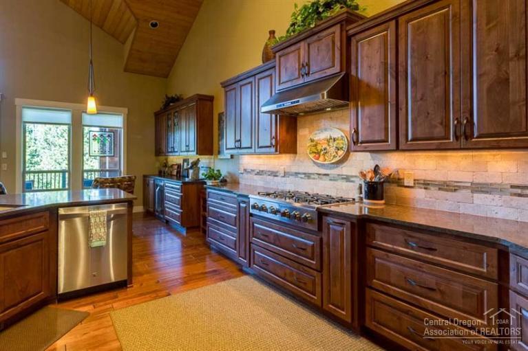 22 Oregon Loop Sunriver, OR 97707 - Photo 8 of 25 a kitchen with granite countertop wooden cabinets a sink and a stove