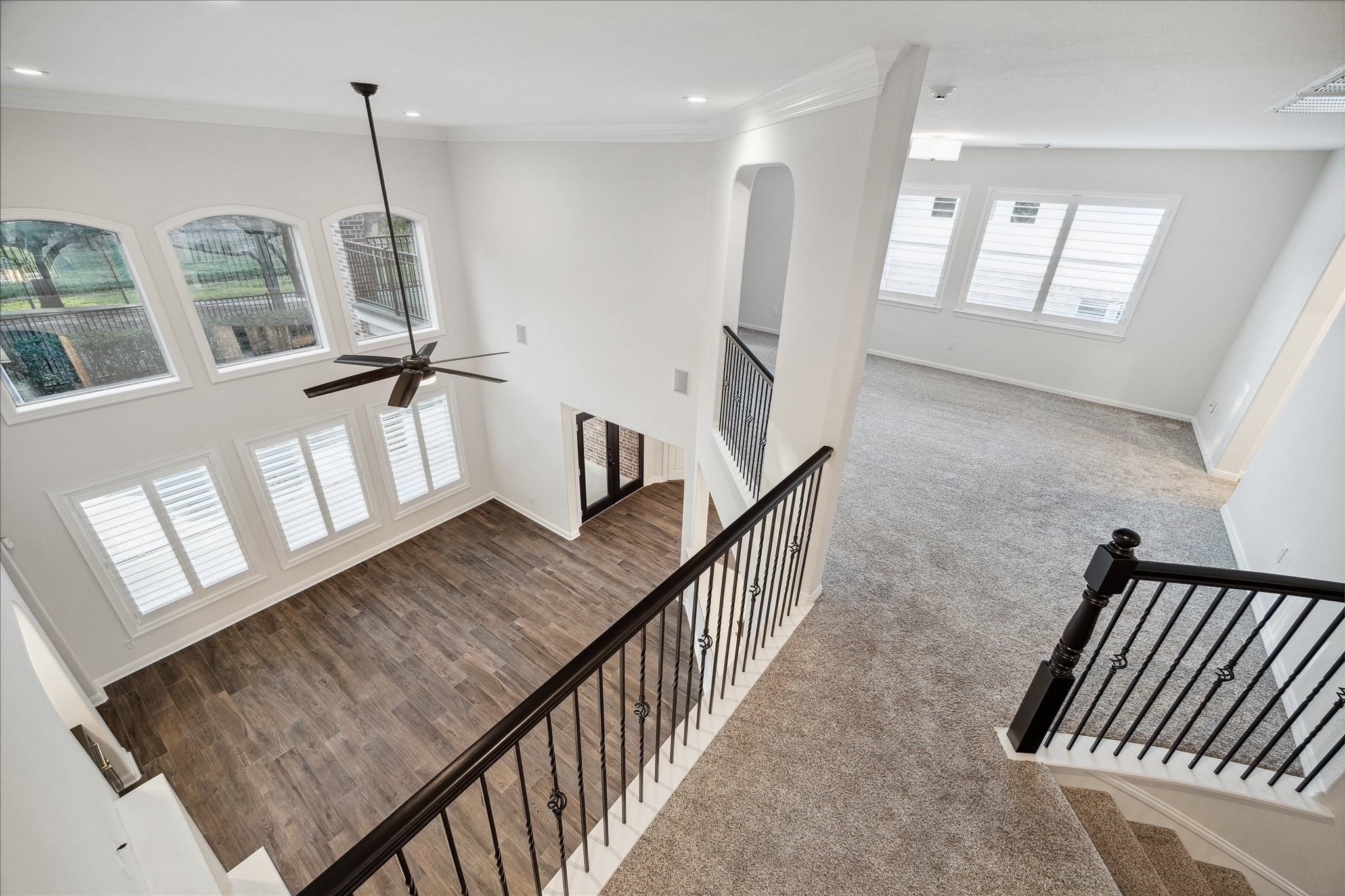 6211 Alameda Point Lane Houston, TX 77041 - Photo 37 of 50 View from the upstairs landing showcasing the elegant iron staircase railing, open layout, and seamless flow between the game room and secondary bedrooms.