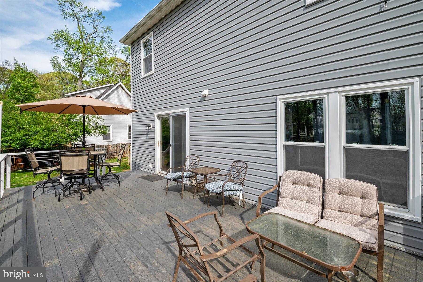 4904 Beech Street Shady Side, MD 20764 - Photo 11 of 26 a view of a patio with a dining table and chairs under an umbrella