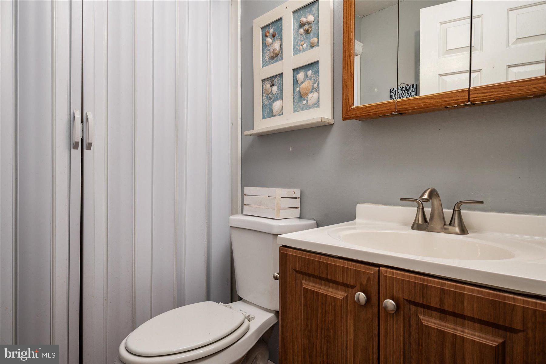 4904 Beech Street Shady Side, MD 20764 - Photo 14 of 26 a bathroom with a sink a toilet and shower curtain