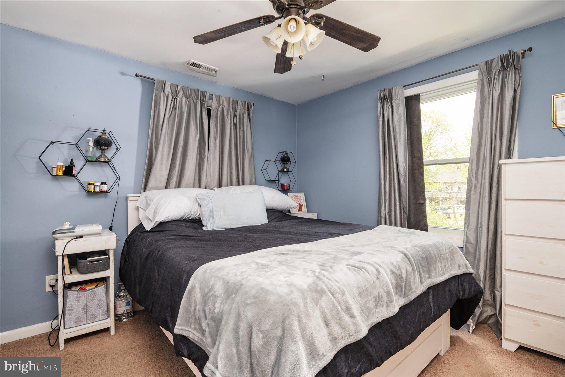 4904 Beech Street Shady Side, MD 20764 - Photo 16 of 26 a bedroom with a bed and a chandelier