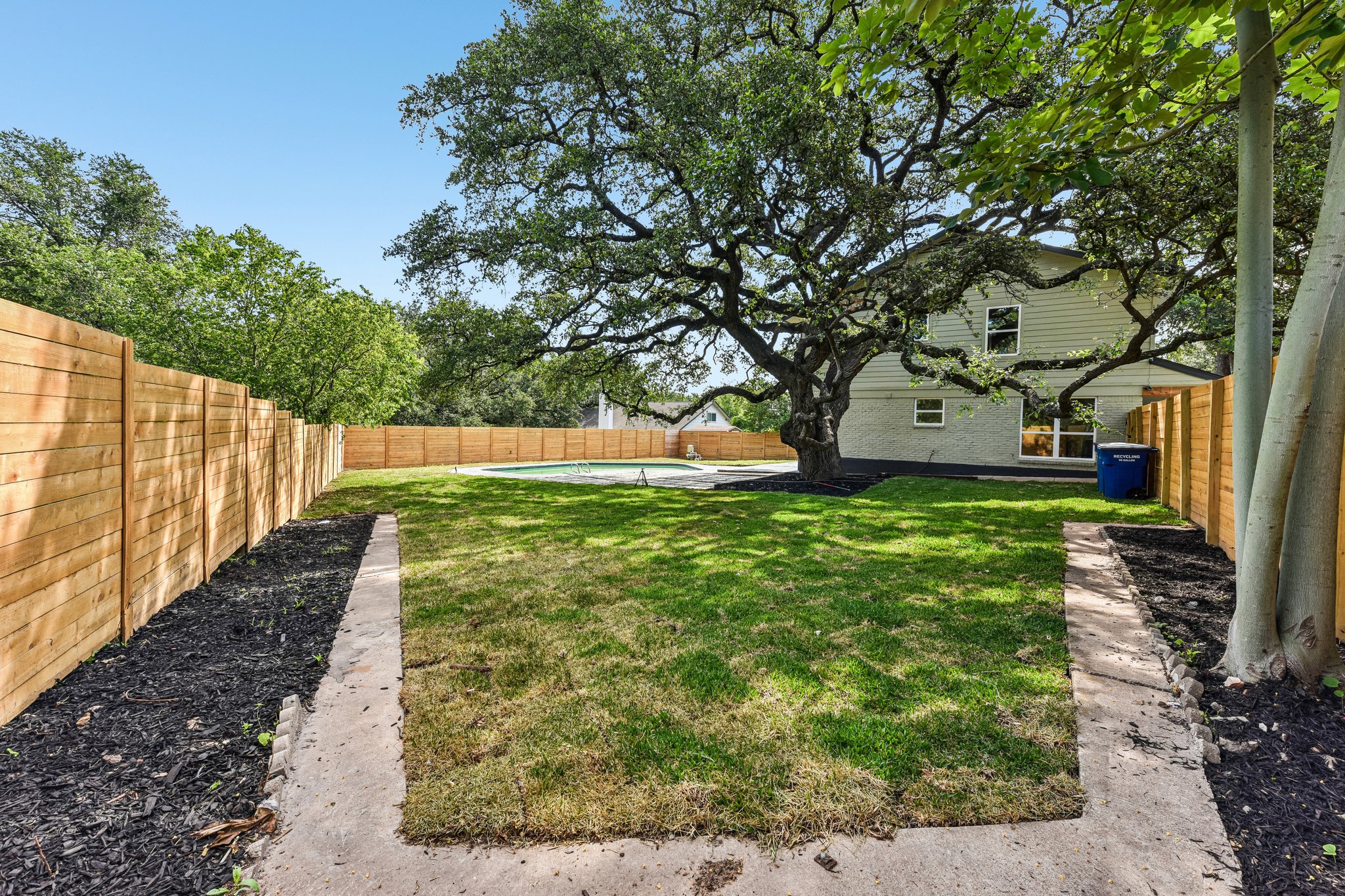 7523 Glenhill Road Austin, TX 78752 - Photo 38 of 38 A spacious yard with mature shade trees, a refreshing pool, and privacy fencing.