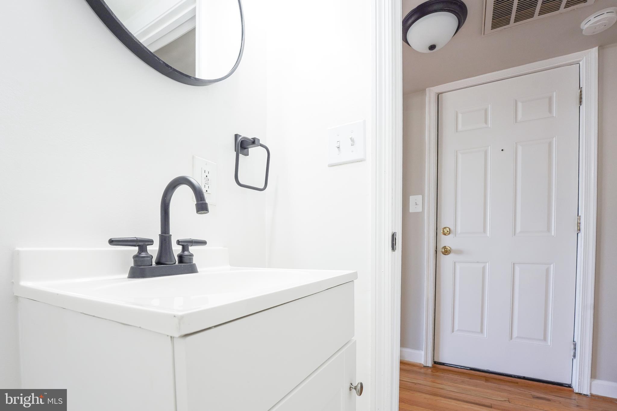 1823 H Place Northeast, Unit 3 Washington, DC 20002 - Photo 7 of 16 a close view of a sink a mirror and a shower in a bathroom