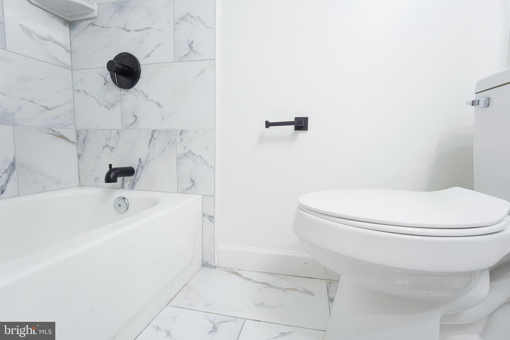 1823 H Place Northeast, Unit 3 Washington, DC 20002 - Photo 8 of 16 a bathroom with a sink a toilet and a tub