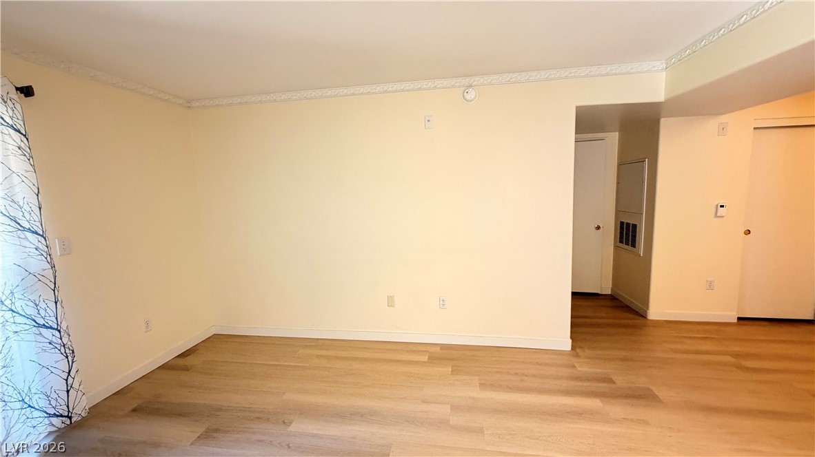 7885 West Flamingo Road, Unit 1131 Las Vegas, NV 89147 - Photo 14 of 36 A well-maintained living area features elegant crown molding and wood flooring.