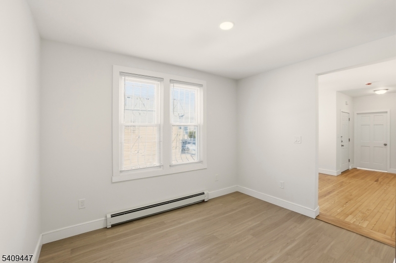 196 2nd Street Newark, NJ 07107 - Photo 2 of 9 an empty room with wooden floor and windows