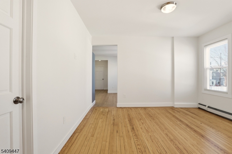 196 2nd Street Newark, NJ 07107 - Photo 3 of 9 a view of a room with wooden floor and a window