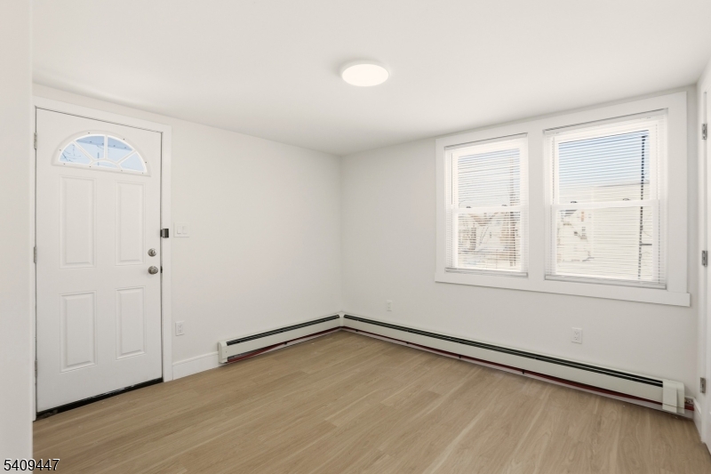 196 2nd Street Newark, NJ 07107 - Photo 7 of 9 an empty room with wooden floor and windows