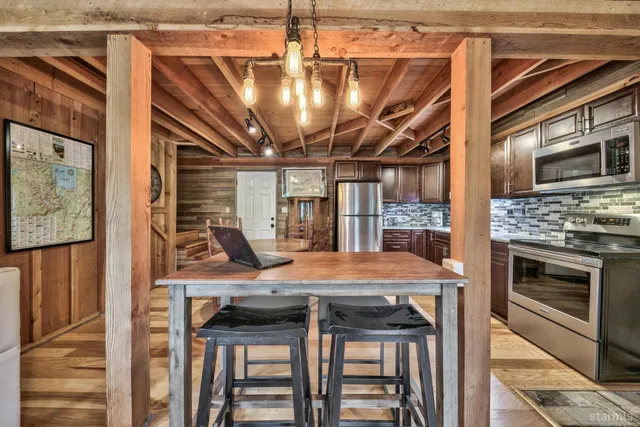 a kitchen with a stove a refrigerator and wooden floor