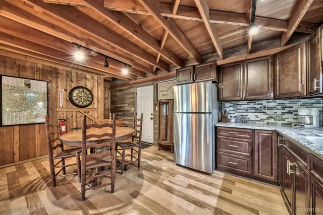a view of a kitchen with stainless steel appliances granite countertop a refrigerator and a stove top oven