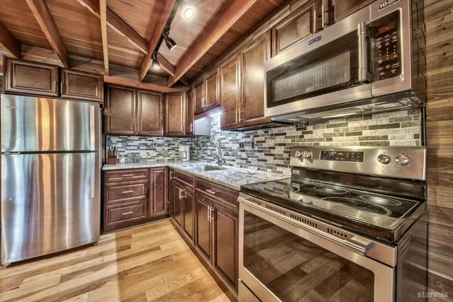 a kitchen with stainless steel appliances granite countertop a stove and a microwave