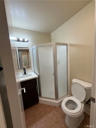 a bathroom with a granite countertop toilet sink and mirror