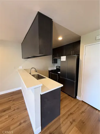 a kitchen with stainless steel appliances granite countertop a sink a refrigerator and a microwave