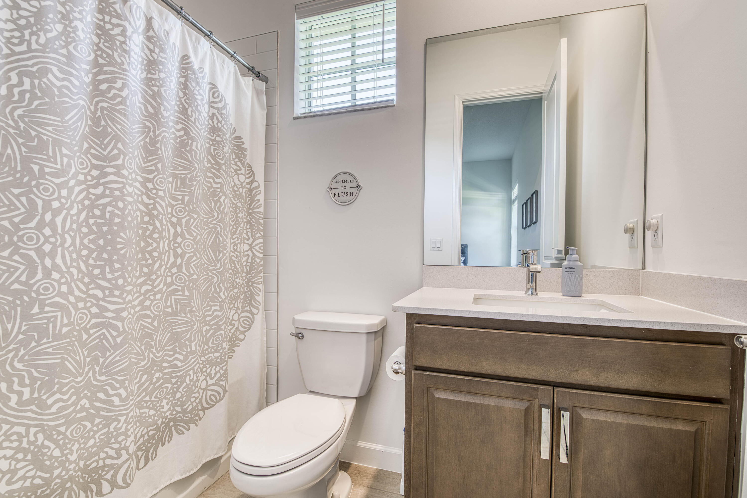 19017 Fly Rod Run Loxahatchee, FL 33470 - Photo 42 of 106 a bathroom with a sink a toilet a mirror and shower curtain