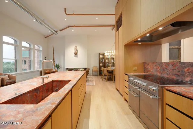 a large kitchen with granite countertop a large counter top and stainless steel appliances