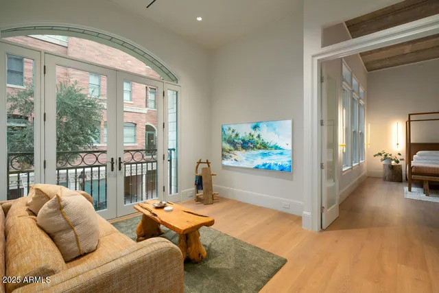 a bedroom with a bed and large window with balcony view