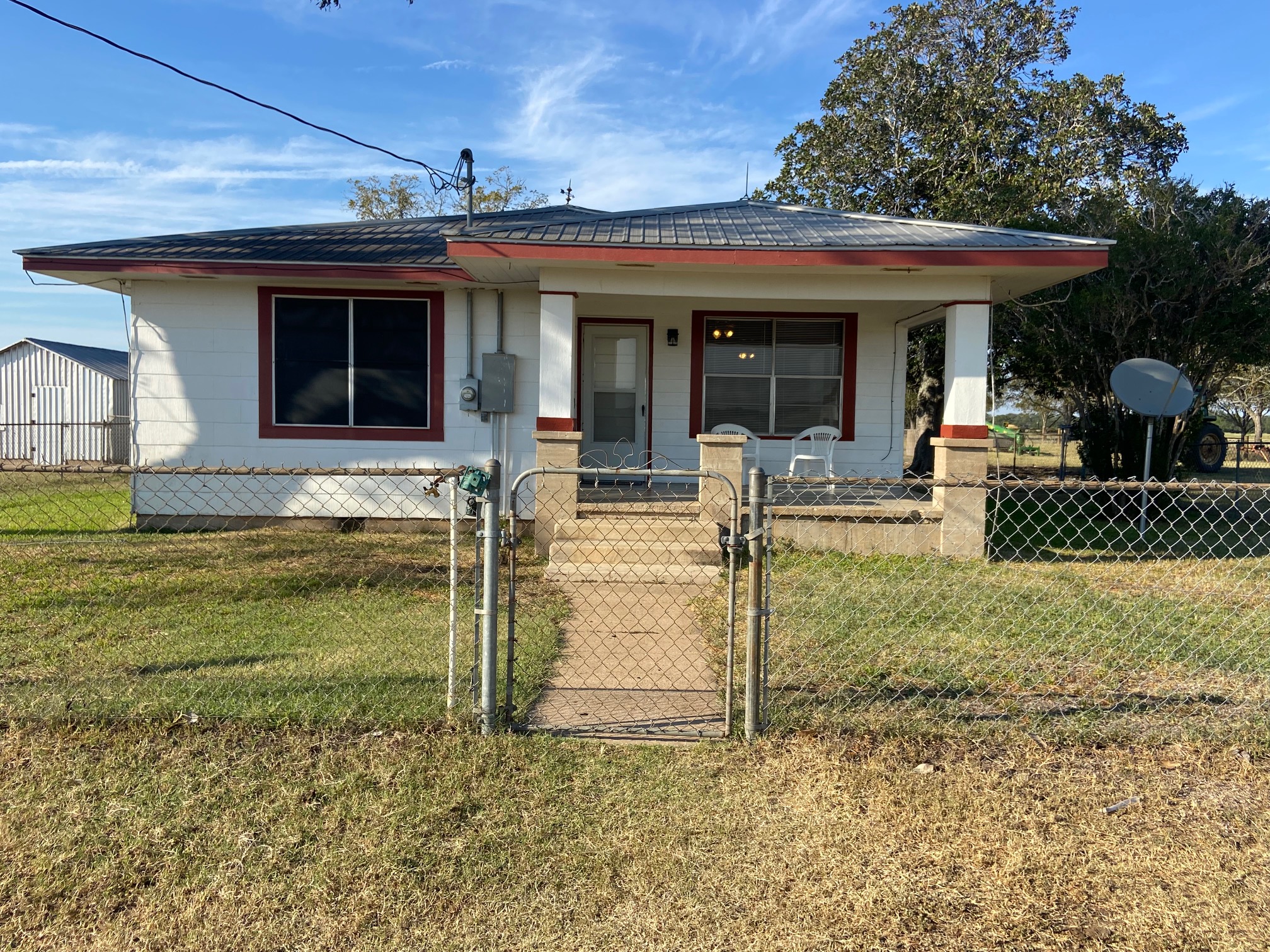 View of front facade featuring a gate, a porch, and a fenced front yard