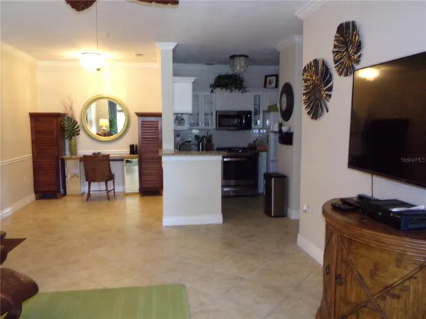 a living room with furniture a flat screen tv and kitchen area