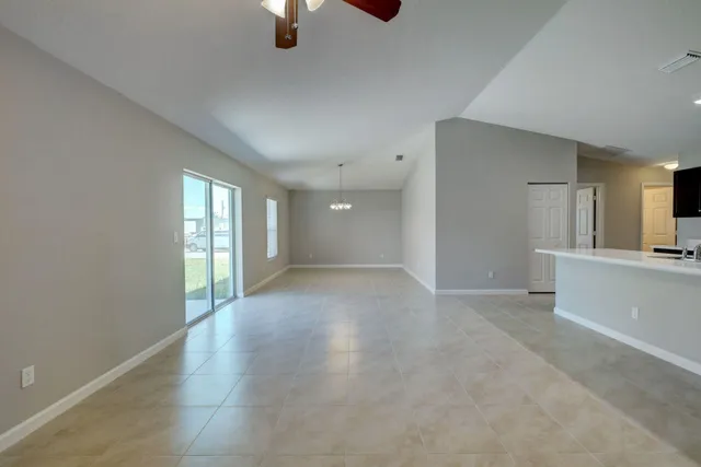 an empty room with chandelier and windows