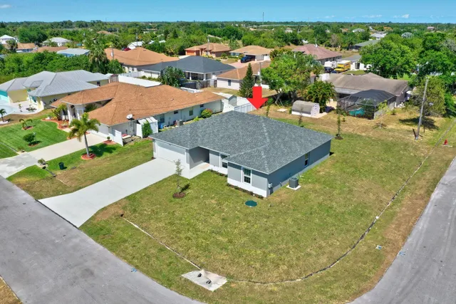 an aerial view of a house with swimming pool and mountains