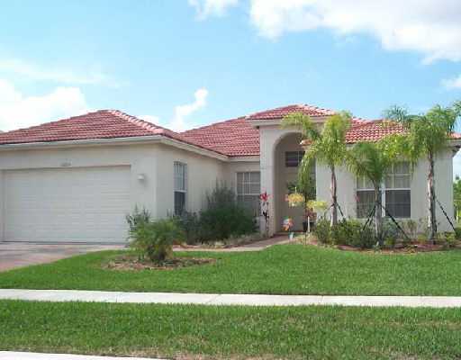 a front view of a house with a garden and plants