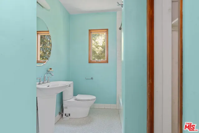 a bathroom with a toilet sink and mirror