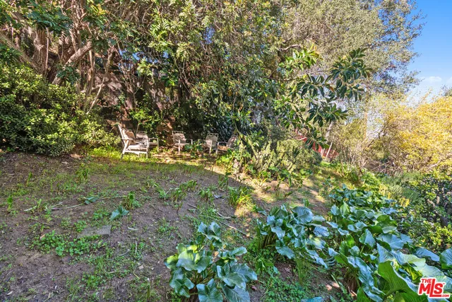 an aerial view of house with yard and mountain view in city