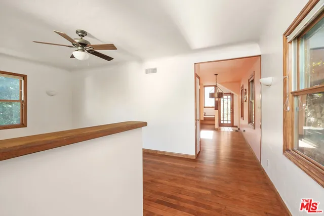 a view of a hallway with wooden floor and staircase