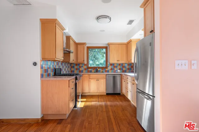 a kitchen with stainless steel appliances a refrigerator and a stove top oven