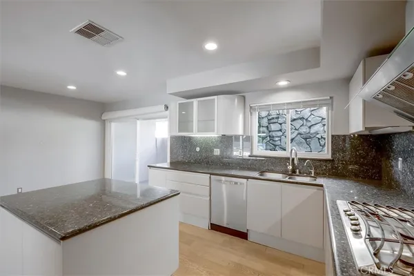a kitchen with stainless steel appliances granite countertop a refrigerator and a sink