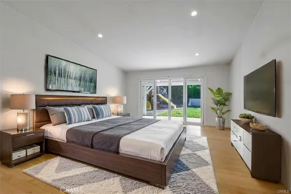 a bedroom with a bed and a flat screen tv