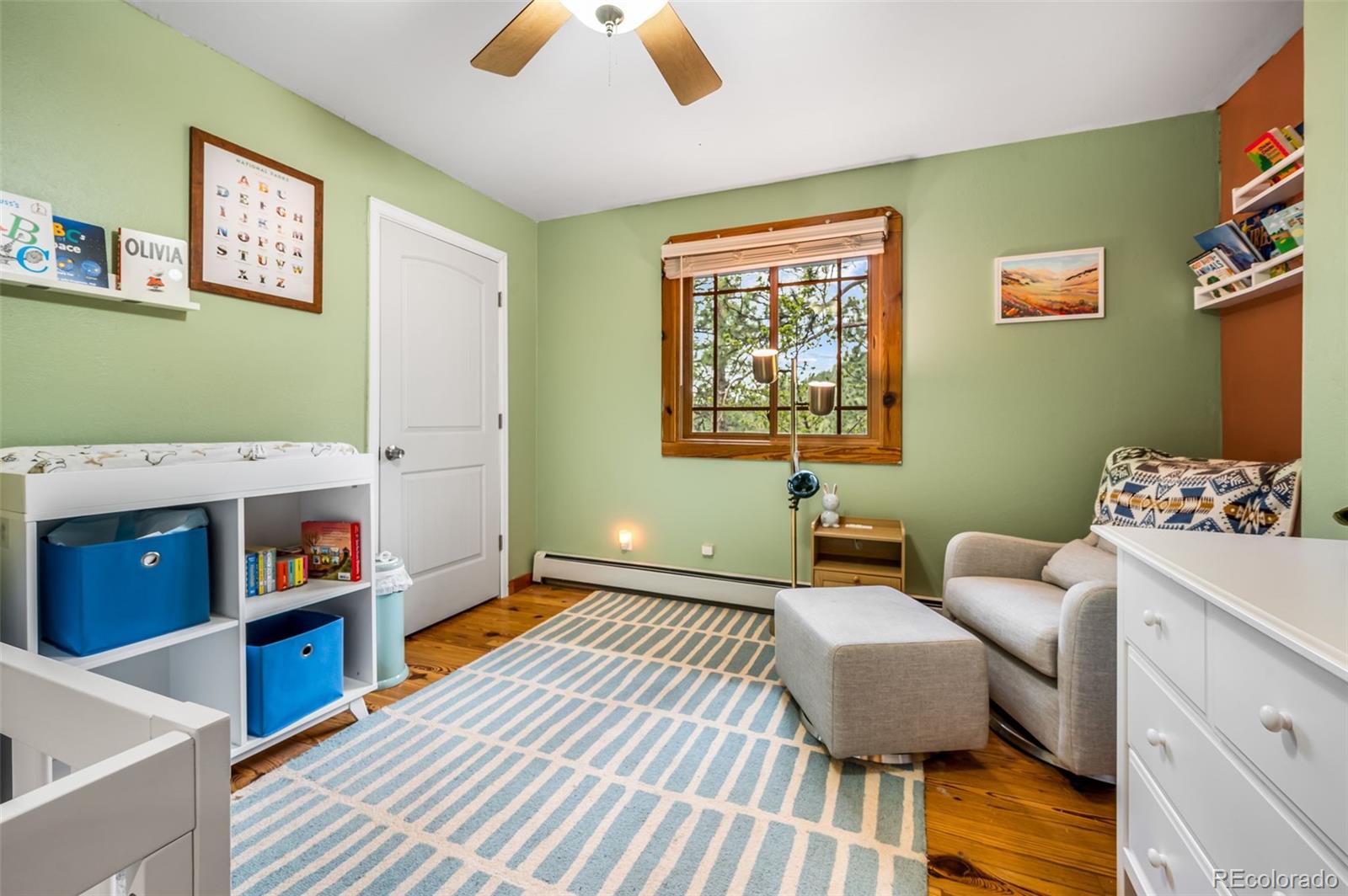 30315 Lone Spruce Road Evergreen, CO 80439 - Photo 17 of 48 a bedroom with furniture and a wooden floor