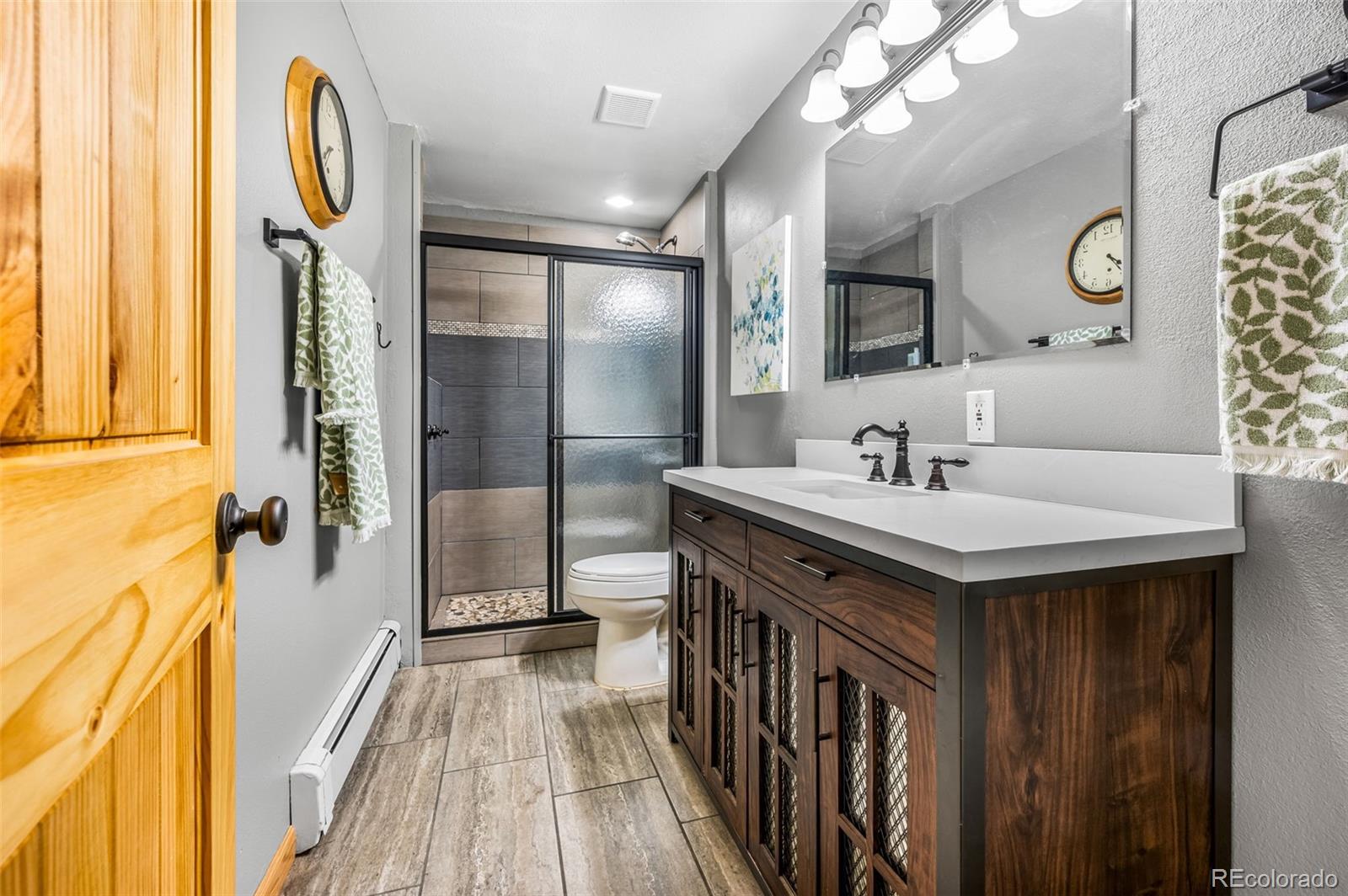 30315 Lone Spruce Road Evergreen, CO 80439 - Photo 24 of 48 a bathroom with a sink a mirror and a shower