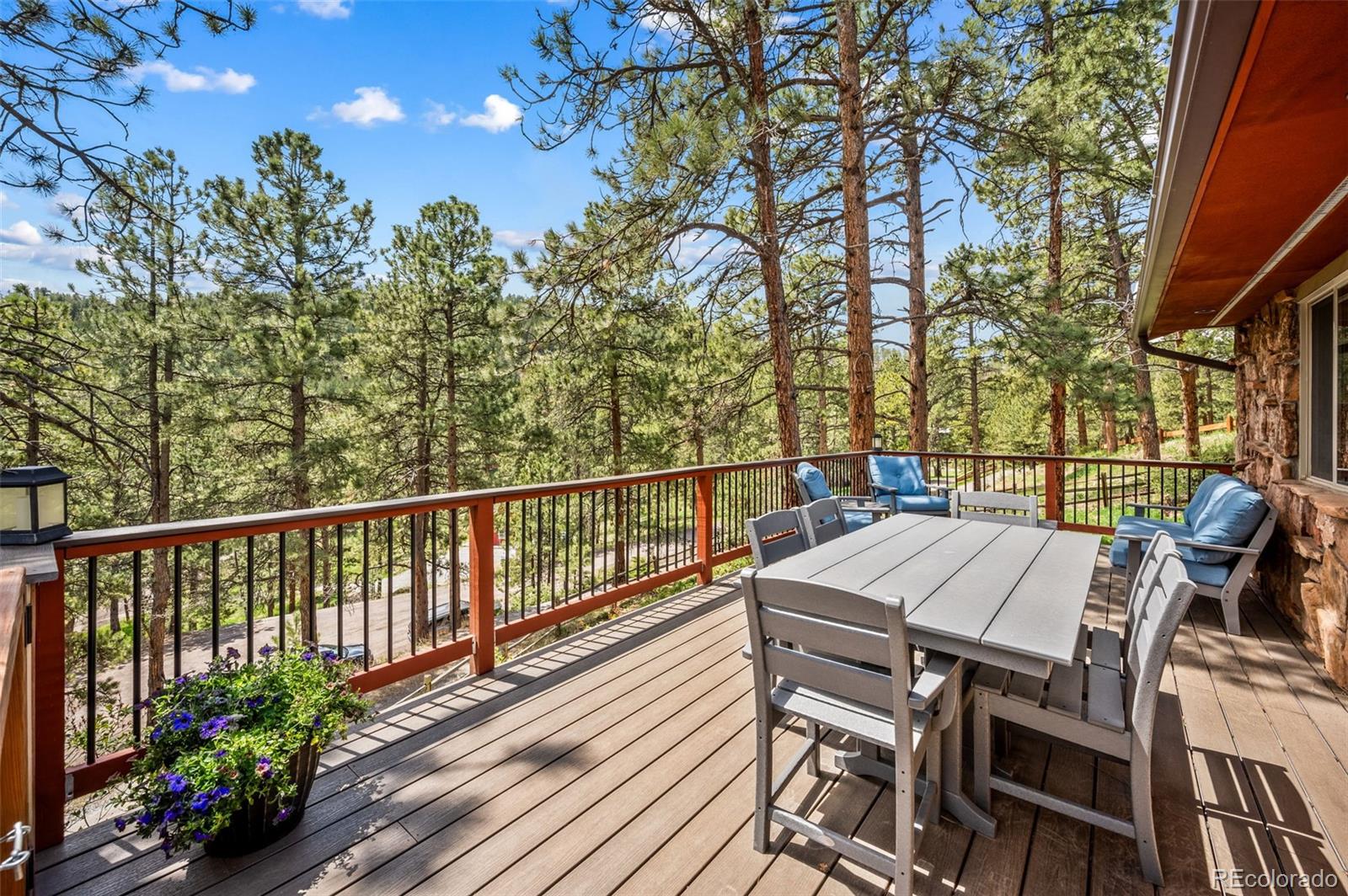30315 Lone Spruce Road Evergreen, CO 80439 - Photo 28 of 48 a view of a chairs and table on the deck