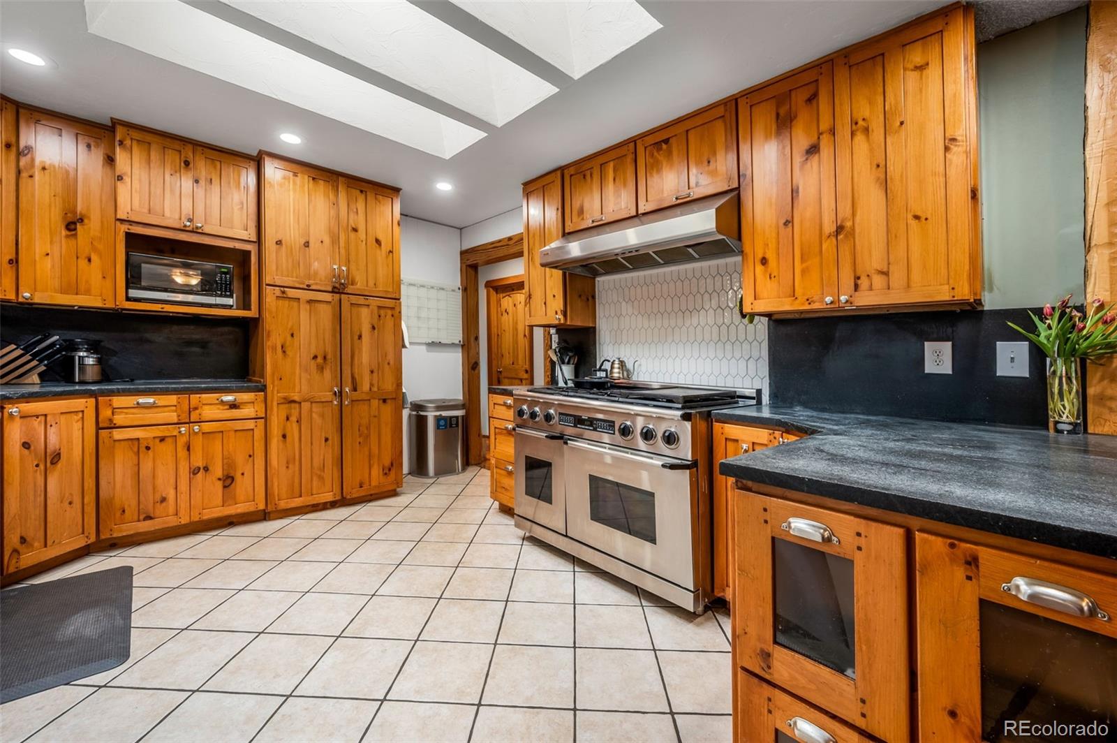 30315 Lone Spruce Road Evergreen, CO 80439 - Photo 5 of 48 a kitchen with stainless steel appliances granite countertop a stove a sink and a microwave
