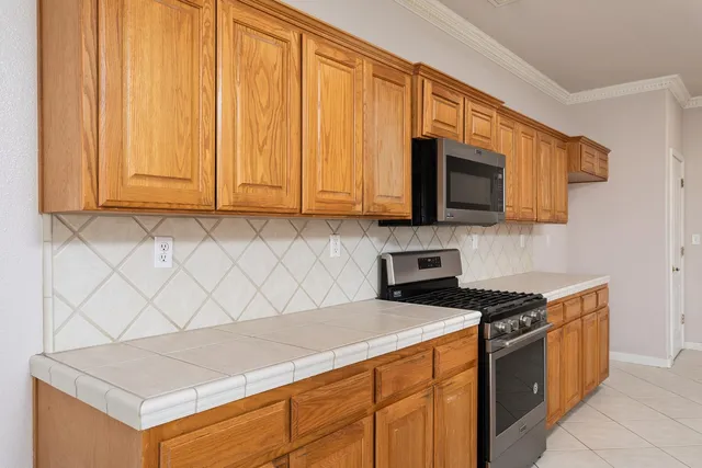 a kitchen with stainless steel appliances a sink a microwave a refrigerator and cabinets
