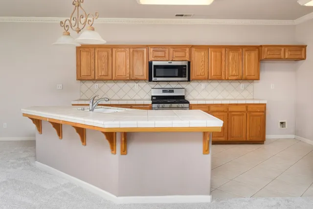 a kitchen with stainless steel appliances granite countertop a sink a stove and a microwave