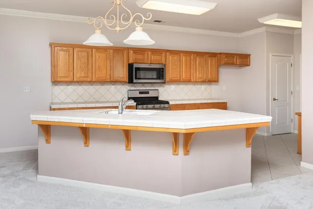 a kitchen with stainless steel appliances a sink stove and microwave