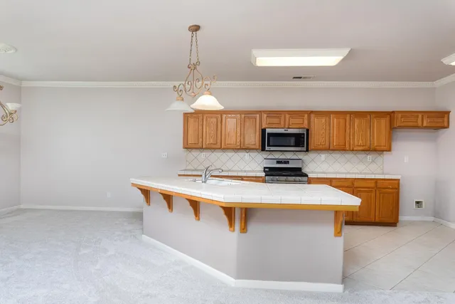 a kitchen with granite countertop cabinets stainless steel appliances and a counter space