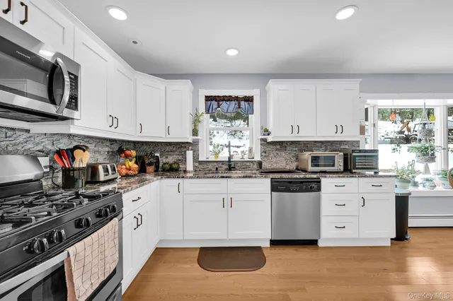 a kitchen with stainless steel appliances granite countertop a stove sink and cabinets