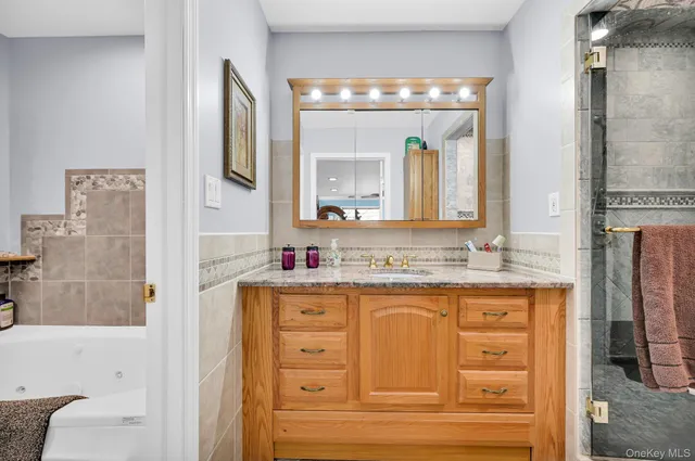 a bathroom with a granite countertop sink vanity and mirror