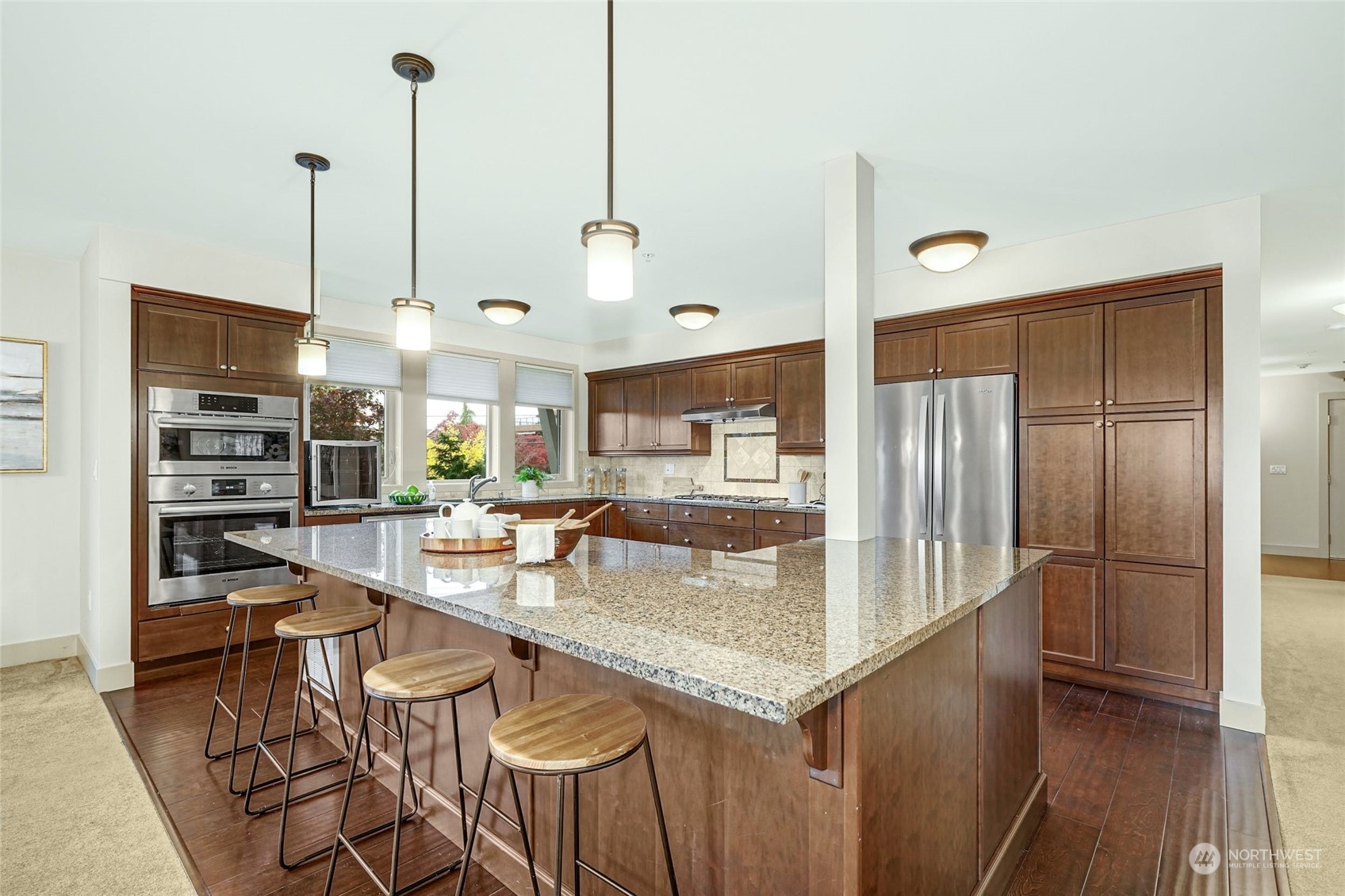 316 Walnut Street, Unit 201 Edmonds, WA 98020 - Photo 12 of 29 a kitchen with stainless steel appliances kitchen island granite countertop a table chairs and a view of living room